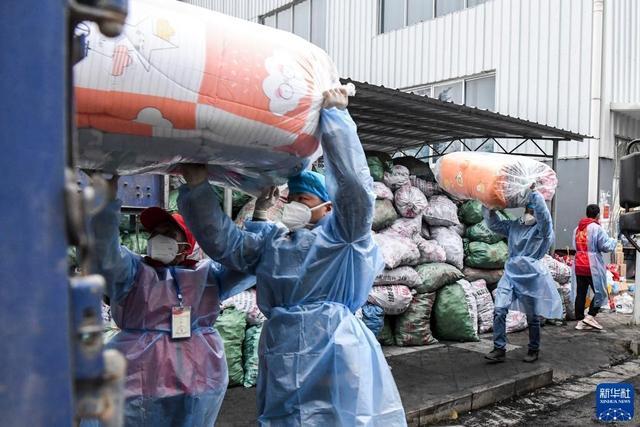 2月11日,工作人员在德保县一处仓库外搬运刚运来的抗疫物资.